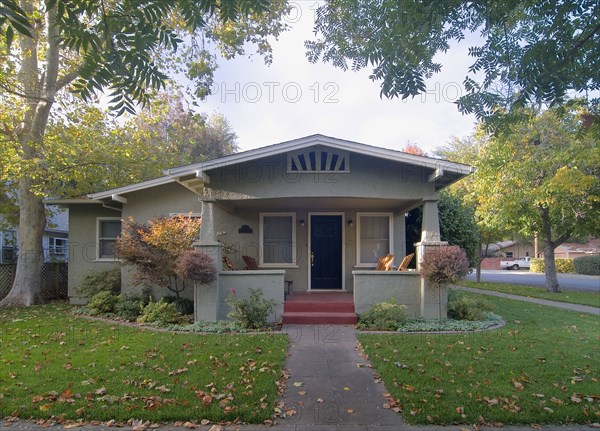 Front exterior view of a green bungalow