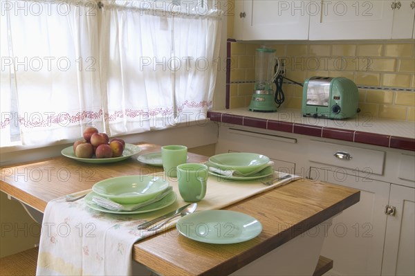 Detail place settings on kitchen table in small vintage kitchen