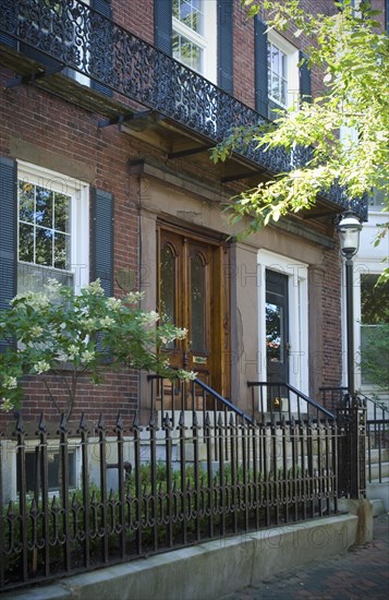 Brick apartment building with wrought iron fence