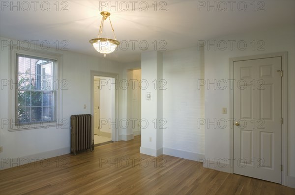 Empty room in apartment with hardwood floor and heater