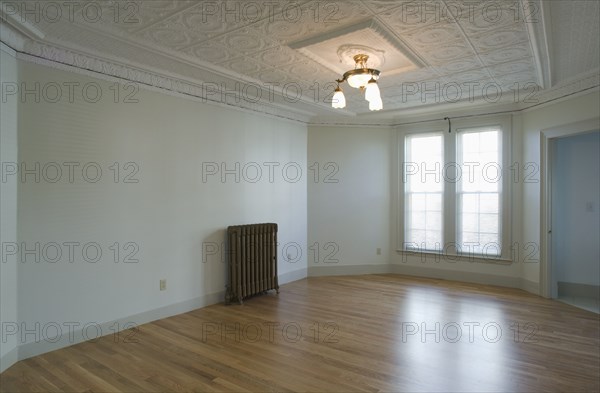 Empty room in apartment with hardwood floor and heater