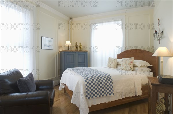 Bed and armchair in small studio apartment