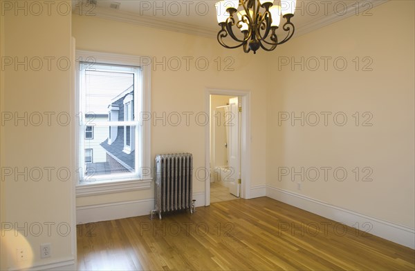 Empty room in apartment with hardwood floor and heater