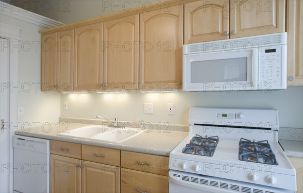 Empty kitchen with light colored cabinets