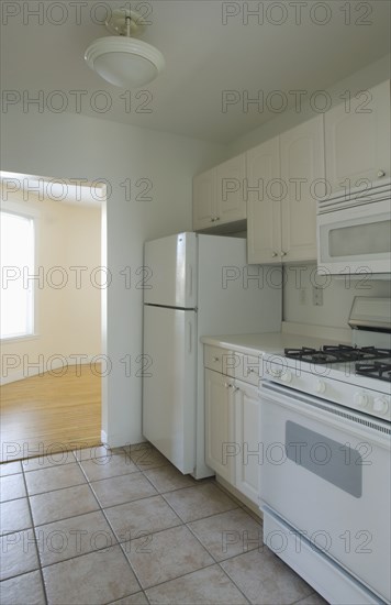 White stove and kitchen in empty apartment