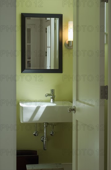 View of bathroom sink through open door