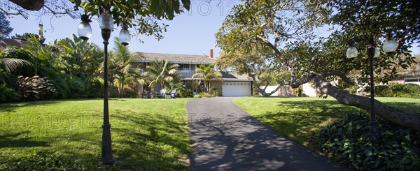 Lawn with driveway leading to multiple story home