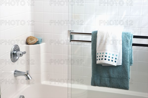 Towels on sliding glass shower door in bathroom