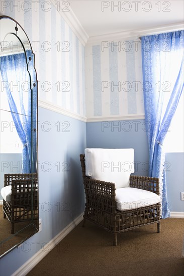 Wicker armchair in corner of bedroom