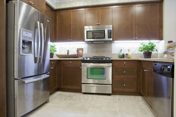 Kitchen with brown cabinets and stainless steel refrigerator at home