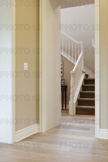 Hallway leading to stairs with banister at home