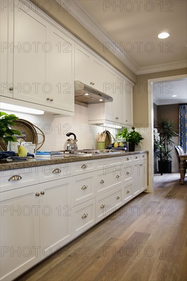 Kitchen having white cabinets and wooden floor at home