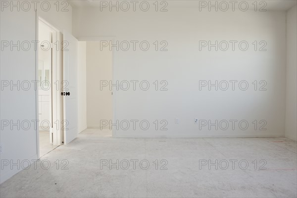 Empty room with doorways and white floor