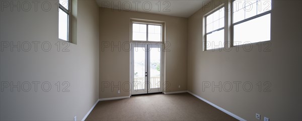 Empty room with windows and closed door