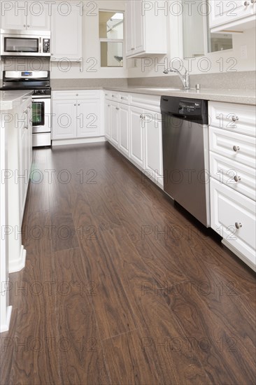 Kitchen having white cabinets and wooden floor at home