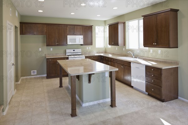 Kitchen having brown cabinets and island at home