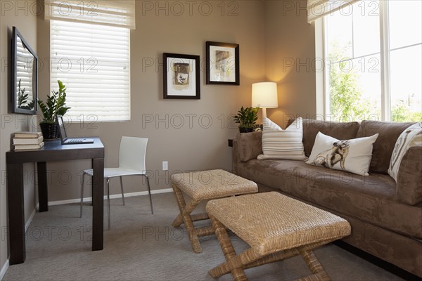 Lit lamp besides couch with study table in the living room at home