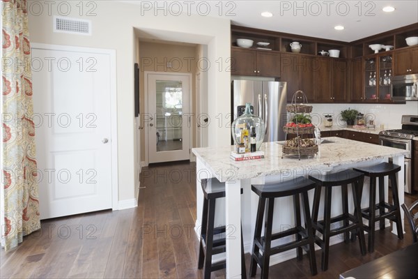 High stools at the kitchen island along hallway at home