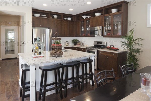 High stools at the kitchen island along hallway at home