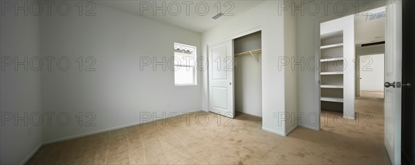 Empty room with open closet door and hallway at home