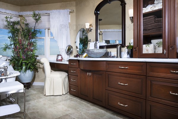 Bathroom with brown cabinets and mirrors at home