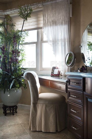 Chair at dressing table in bathroom at home