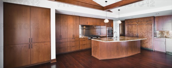 Kitchen having brown cabinets and island at home