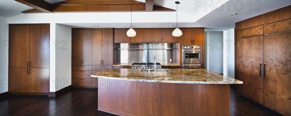 Kitchen having brown cabinets and island at home