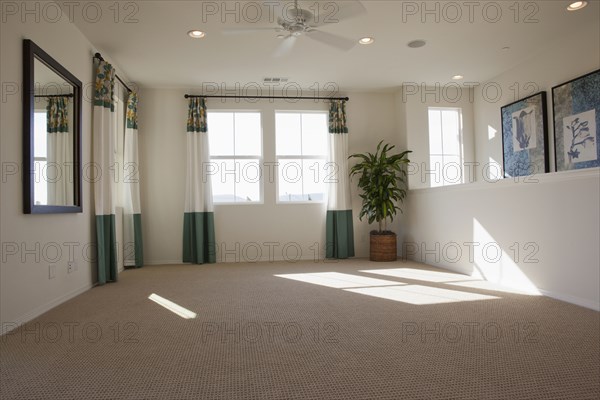 Empty room with carpet on floor and curtains on windows at home