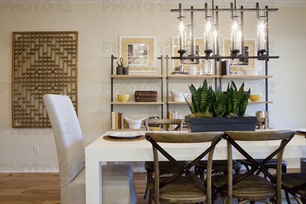 Chairs at dining table with shelves in the background at home