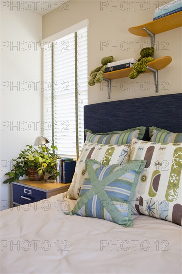 Arranged pillows on tidy bed in the bedroom at home