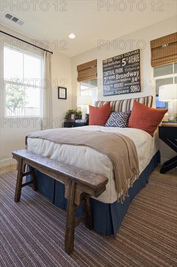 Arranged pillows on tidy bed on carpet floor in the bedroom at home