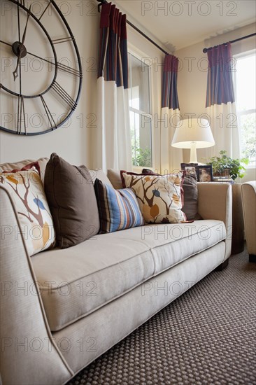 Couch with large wall clock in the living room at home