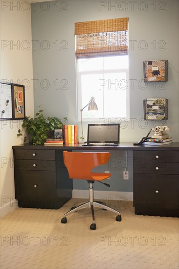 Laptop with books on study table in the house