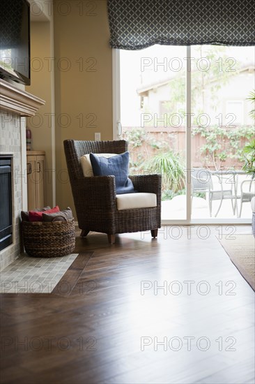 Wicker armchair on hardwood floor in living room