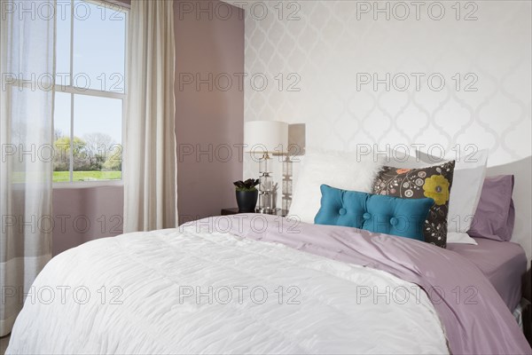 Throw pillows arranged on bed in average house