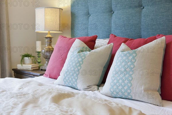 Pillows arranged on bed in middle class bedroom