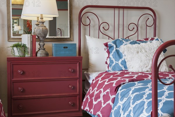 Night table and wrought bed in middle class bedroom