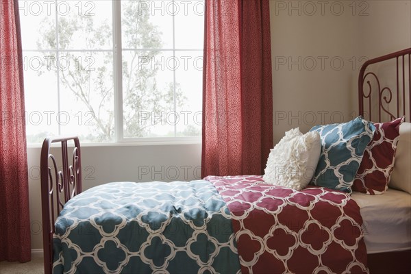 Pillows arranged on bed in middle class house