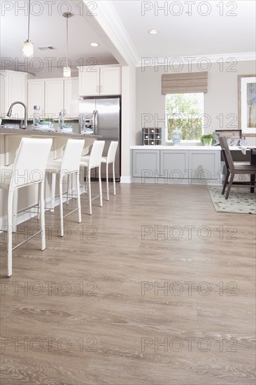 Bar stools at breakfast bar with hardwood flooring