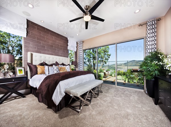 Interior of bedroom with bed end ottoman