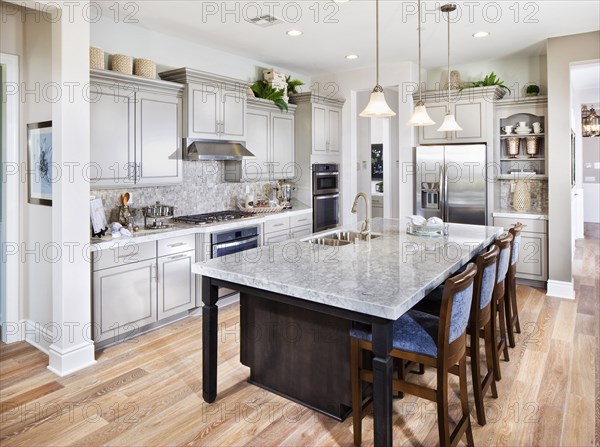 Bar stools at breakfast bar in contemporary kitchen