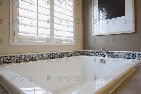 Bathtub by shutter window in master bathroom