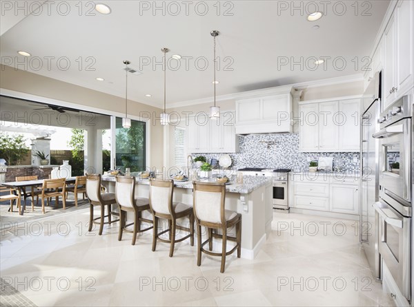 High stools at the kitchen island with dining area in background at home