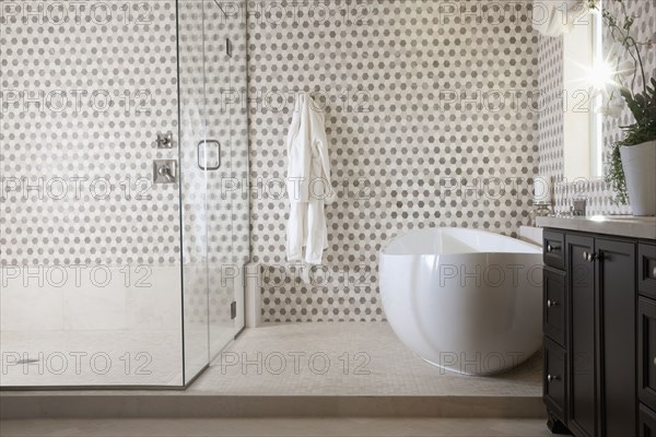 Contemporary bathroom with cropped bath and glass shower at home