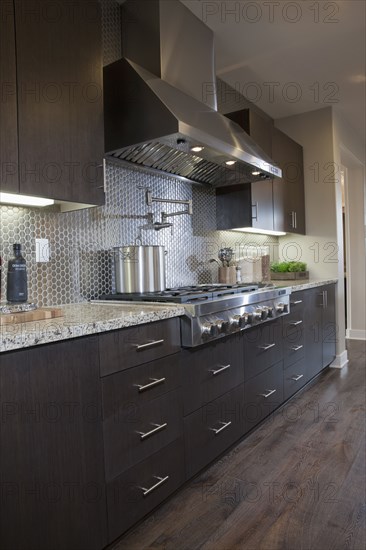 Kitchen having brown cabinets with vent hood at home