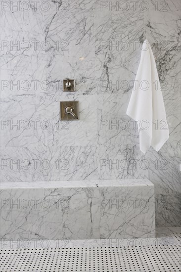 White towel and tap on marble wall in the bathroom at home