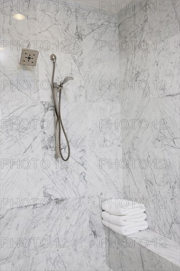 Shower head on marble bathroom wall at home