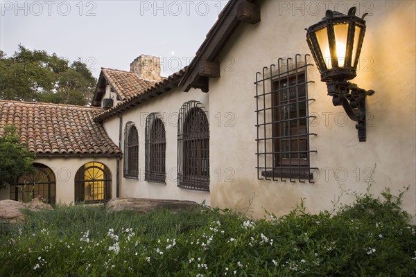 Row of windows with wrought iron grills on side of spanish style home