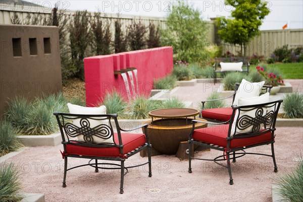 Wrought iron chairs surrounding fire pit in back yard